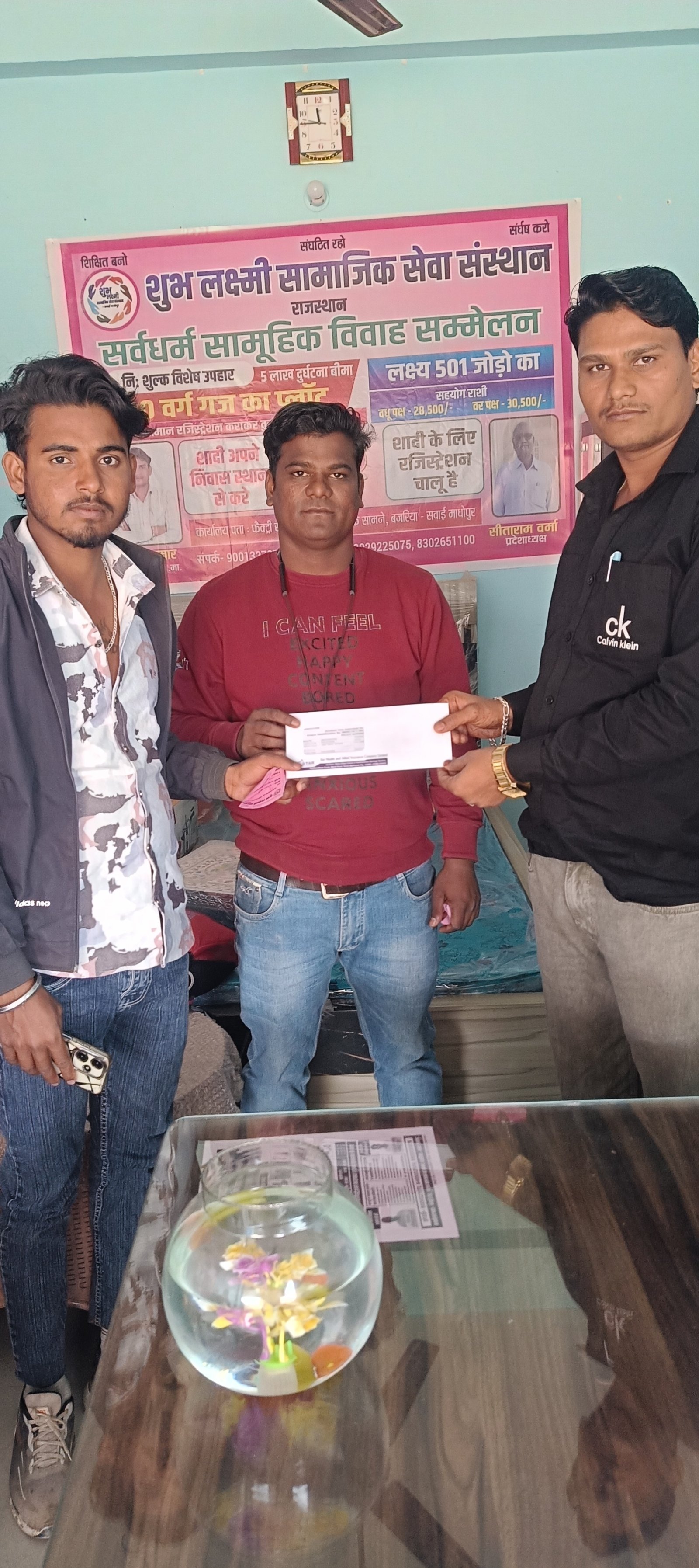 जोड़े को बीमा पॉलिसी देते हुए।